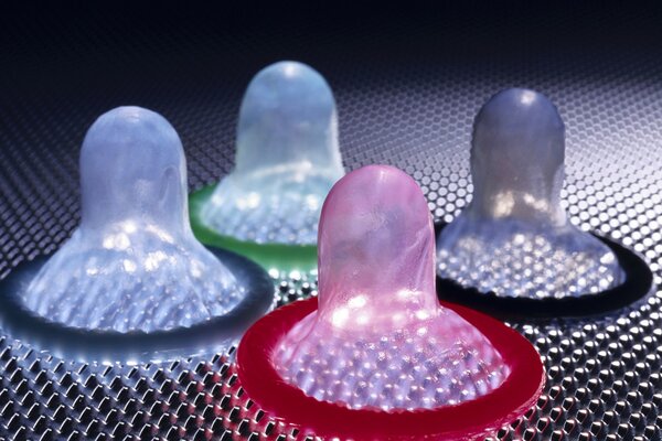 Разноцветные презервативы на темном фоне