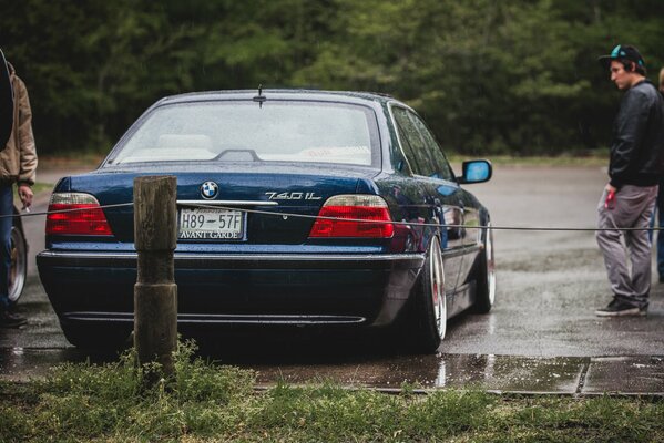 Dark green car on the side of the road near the forest