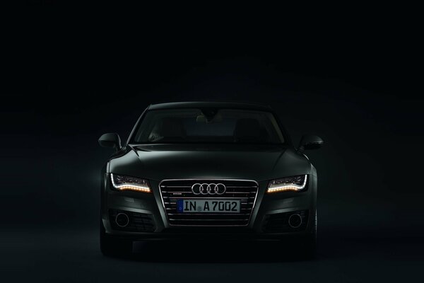 Audi with headlights on in the dark