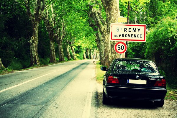 Bmw e38 al lado de la carretera en el bosque