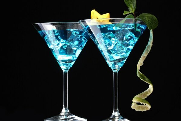 Blue cocktail with ice on a black background