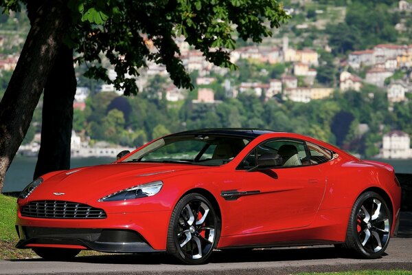 Red aston martin concept against the backdrop of the urban landscape