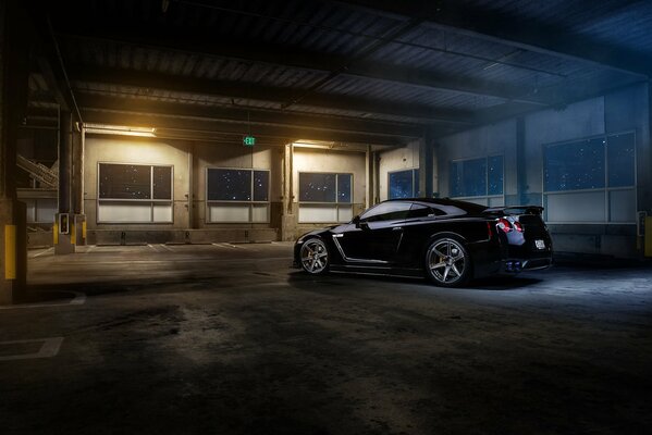 Nissan R35 negro en el estacionamiento del desierto