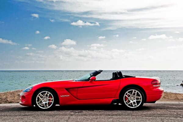 Red car by the water during the day