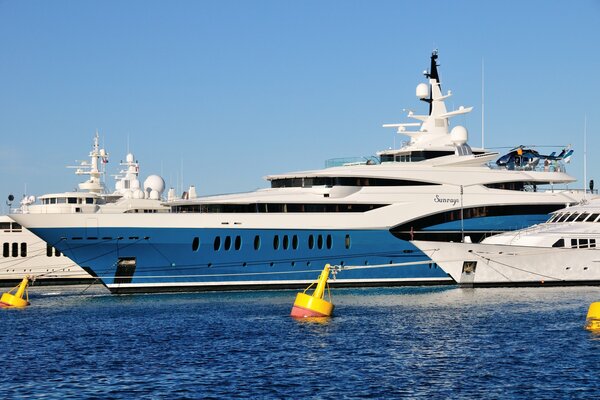 A large white yacht with a helipad