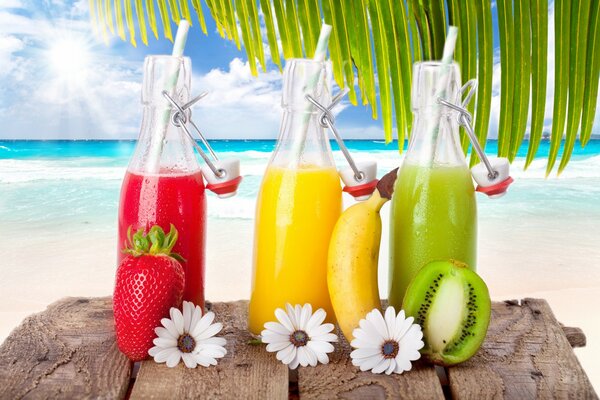 Bottled fruit juices on the background of the sea