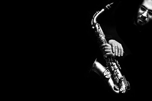 Saxophone in the hands of a man on a dark background