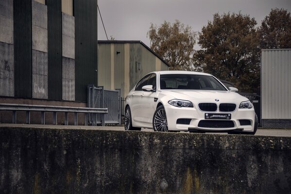 Weißer BMW auf dem Hintergrund von grauen Gebäuden