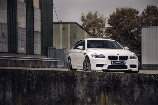 BMW bianca su uno sfondo di edifici grigi