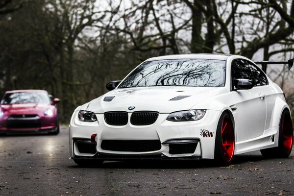 BMW blanco en la carretera de otoño