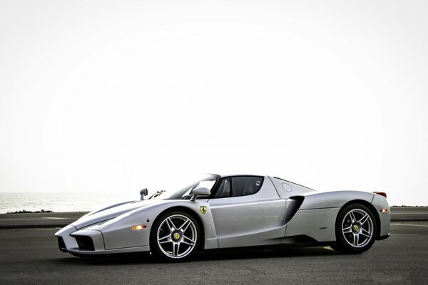 Ferrari plateado en el estacionamiento. El mar en el fondo