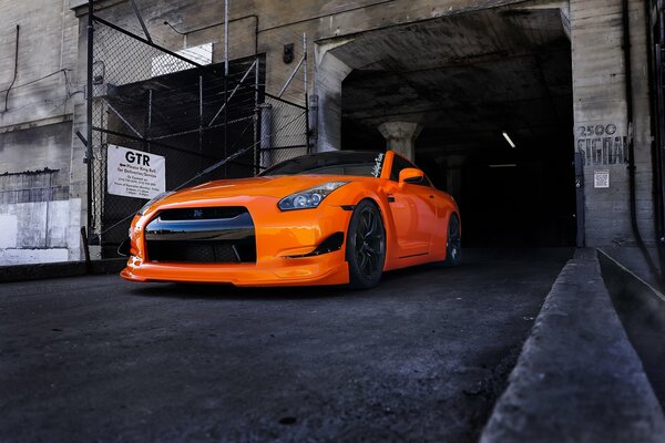 A bright Nissan on a dark road surface background 