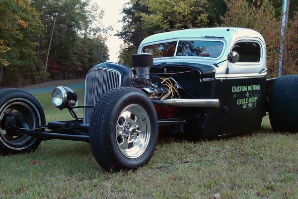 A tuned hot rod car is standing on the lawn