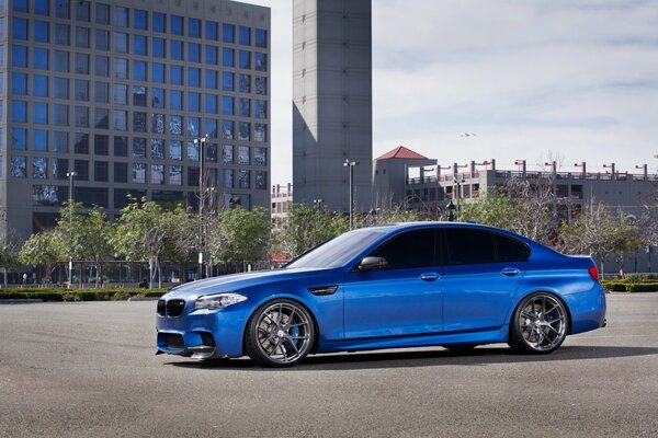 Blaues BMW-Auto auf dem Hintergrund eines mehrstöckigen Gebäudes