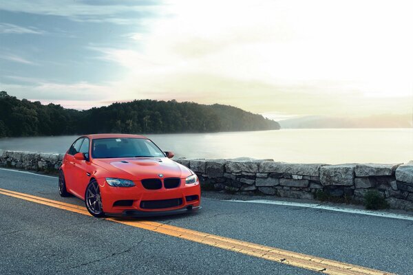 BMW rojo en el fondo de una puesta de sol náutica