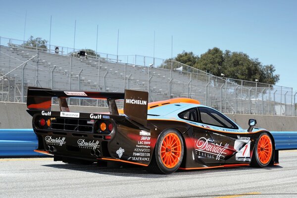 Racing supercar on the background of the stands, rear view 