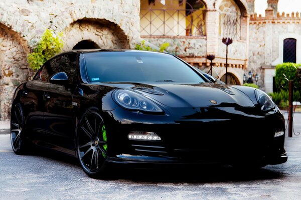 Black Porsche panamera on the background of an ancient city