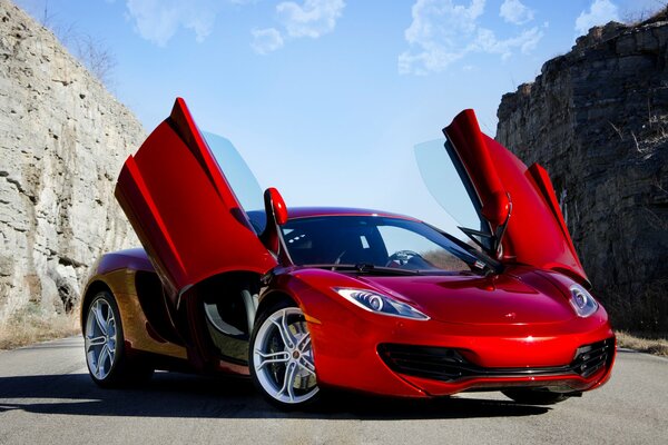 Red McLaren between the rocks against the blue sky