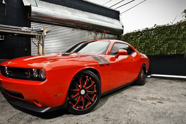 El auto deportivo challenger rojo se encuentra en el garaje