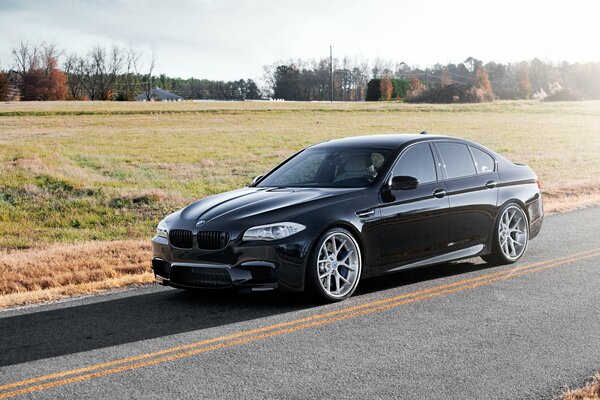 Black BMW F10 on a country road