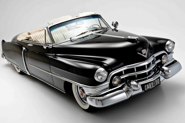 Na białym tle legendarny szykowny czarny Cadillac z otwartym dachem