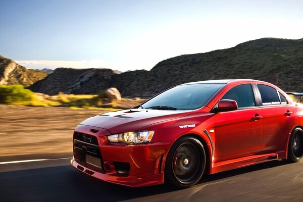 Un Mitsubishi Lancer rojo corre por la carretera de Estados Unidos