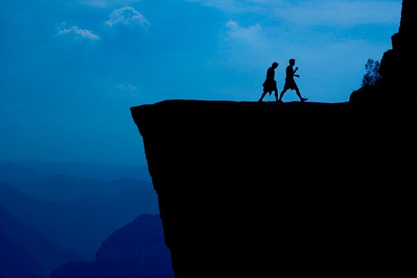 A couple of young people walk away from the cliff