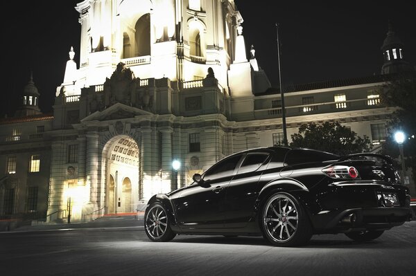 Foto retro del coche negro Mazda en la calle nocturna