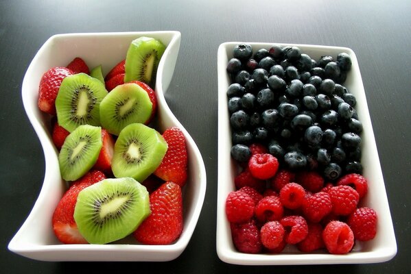 Fruits et baies hachés dans des bols blancs