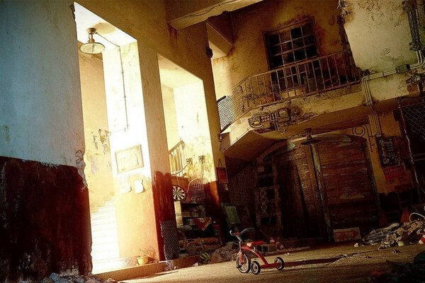 Bicicleta en el patio con basura y escaleras