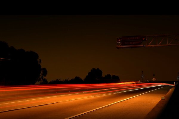 Carretera nocturna entre muchas luces