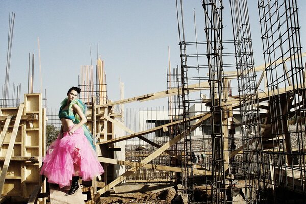 A girl in a bright suit at a construction site