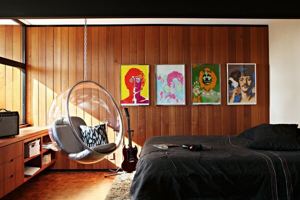 Portraits of the Beatles and a hanging chair in the bedroom interior