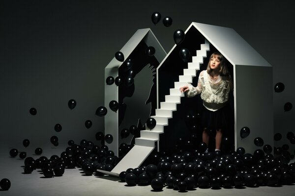 A girl in a house with black balls