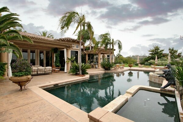 Villa con piscina en medio de palmeras y naturaleza