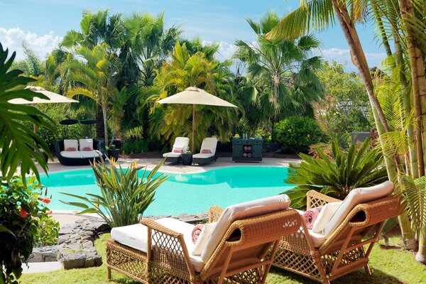 Piscine bleue avec deux transats et parasol