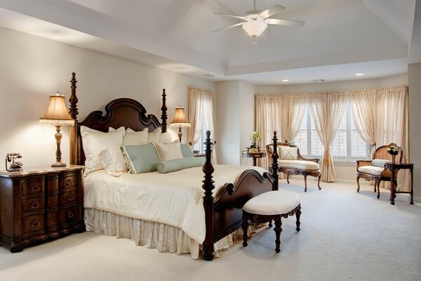 Bedroom design in bright colors with chandelier fan on the ceiling