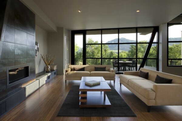 Salone-soggiorno in stile minimalista con divano bianco, BioCamino e finestra panoramica