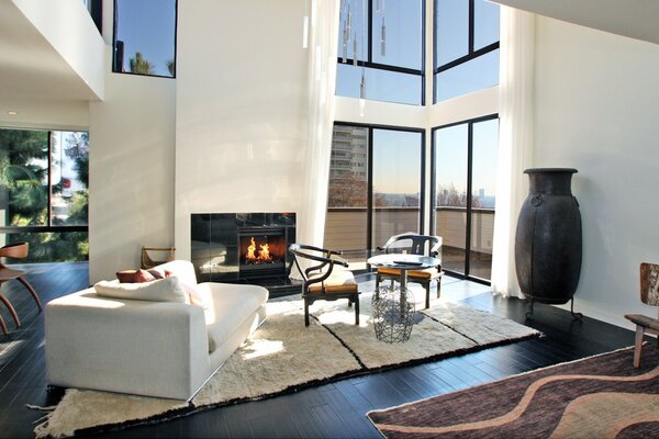 A modern living room in an apartment stylized as a country house with a fireplace and carpets