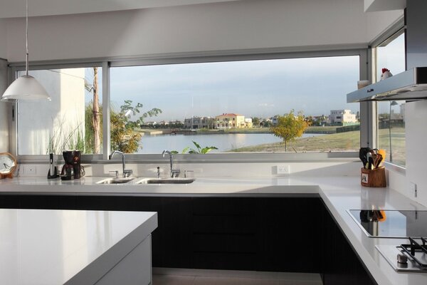 Kitchen with a work surface by the window with a view of the lake and houses