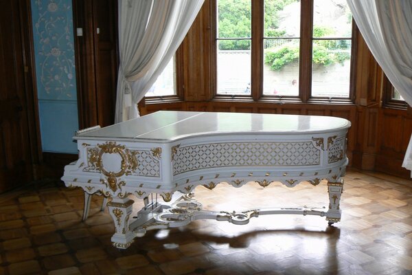 A luxurious piano near the window with white curtains