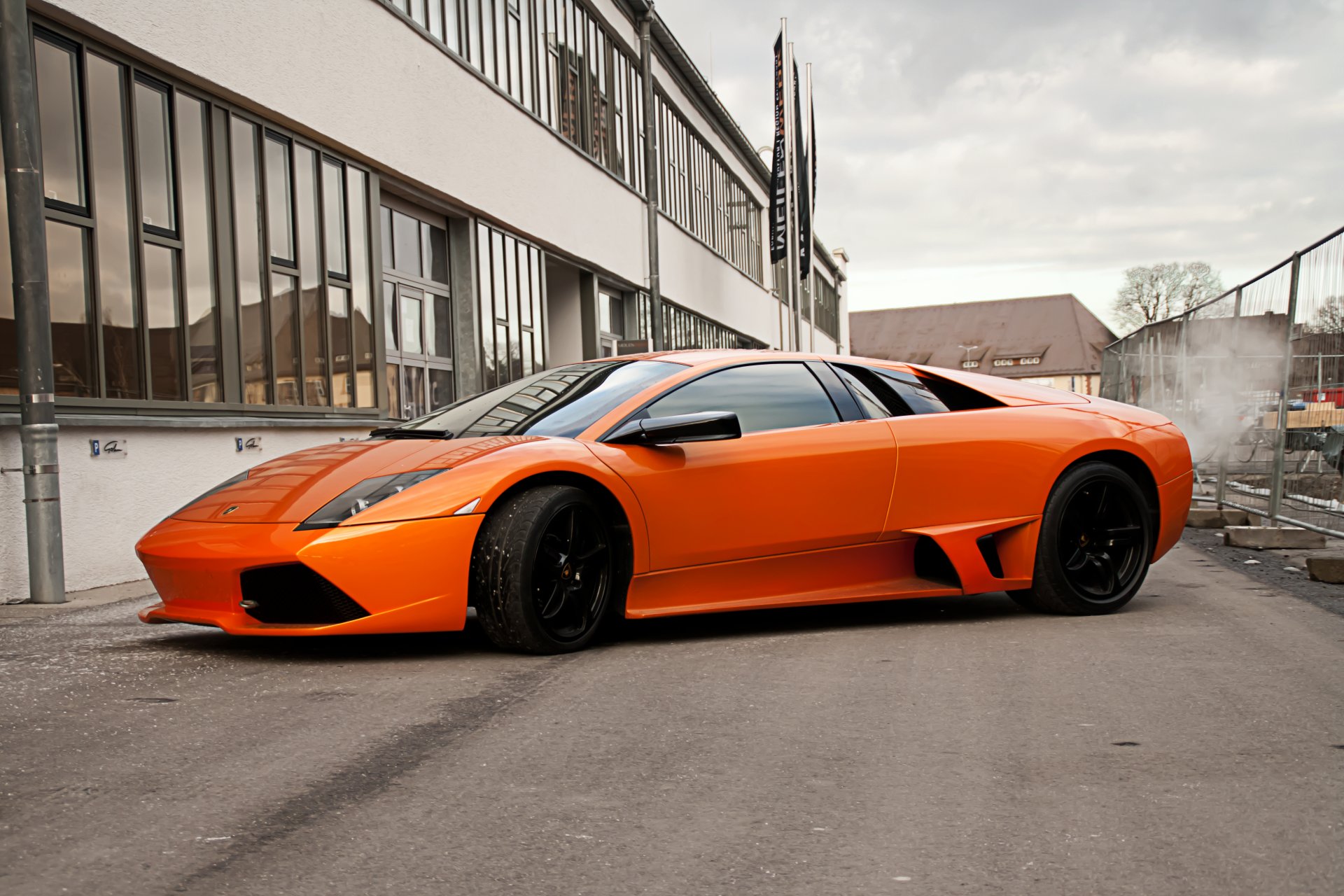 lamborghini murcielago orange lp640 lamborghini murcielago seitenansicht schwarze felgen gebäude fenster geländer himmel wolken