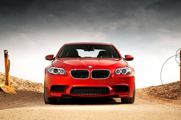 Bmw rojo, m5 en una carretera desierta