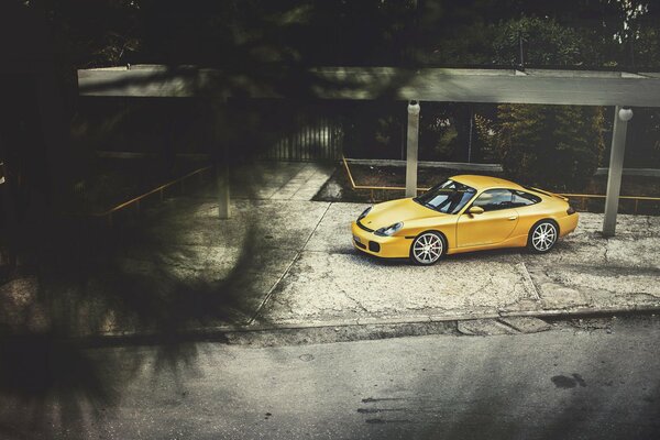 Porsche carrera желтого цвета вид сбоку