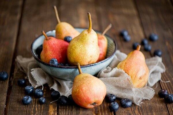 Still life of a pear. Gifts of autumn. Blueberries on the table