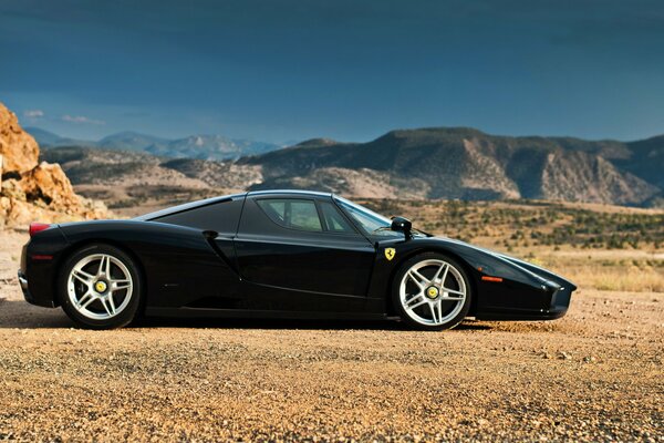 Black ferrari enzo in the mountains on a sunny day