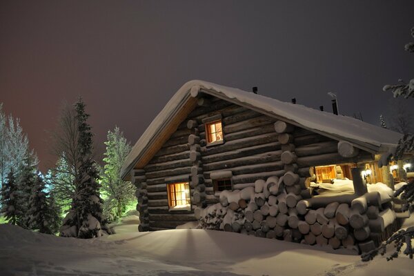 Haus in der Winternacht mit Licht in den Fenstern