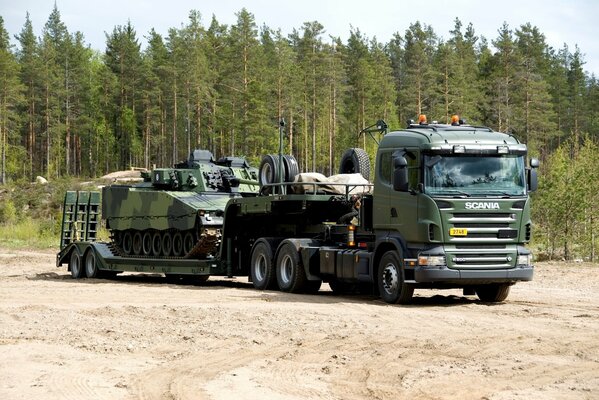 Sattelzugmaschine scania r 5006x4 mit Anhänger für den Transport von Militärfahrzeugen in der finnischen Sonne