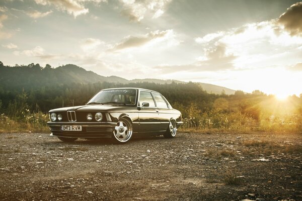 Coche retro al amanecer en medio de las montañas