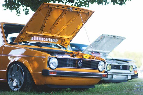 Orangefarbenes Auto mit geöffneter Motorhaube